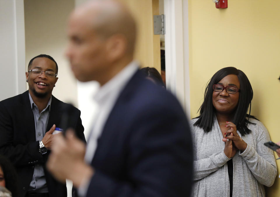 Former chairwoman of the Iowa Democratic Black Caucus Jamie Woods, right, listens as Democratic presidential candidate Sen. Cory Booker speaks during the Iowa Democratic Party Black Caucus Reception, Tuesday, April 16, 2019, in Des Moines, Iowa. In Iowa _ that’s right _ black Democrats are more energized than they’ve been since Barack Obama’s 2008 presidential campaign and are poised to make a mark on the 2020 race. (AP Photo/Charlie Neibergall)