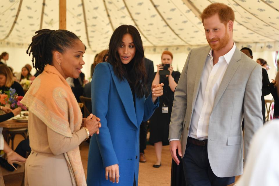 Meghan, Duchess of Sussex (C), her mother, Doria Ragland (L) and Britain's Prince Harry, Duke of Sussex take part in the launch of a cookbook with recipes from a group of women affected by the Grenfell Tower fire at Kensington Palace in London on September 20, 2018. (Photo by Ben STANSALL / POOL / AFP)        (Photo credit should read BEN STANSALL/AFP/Getty Images)