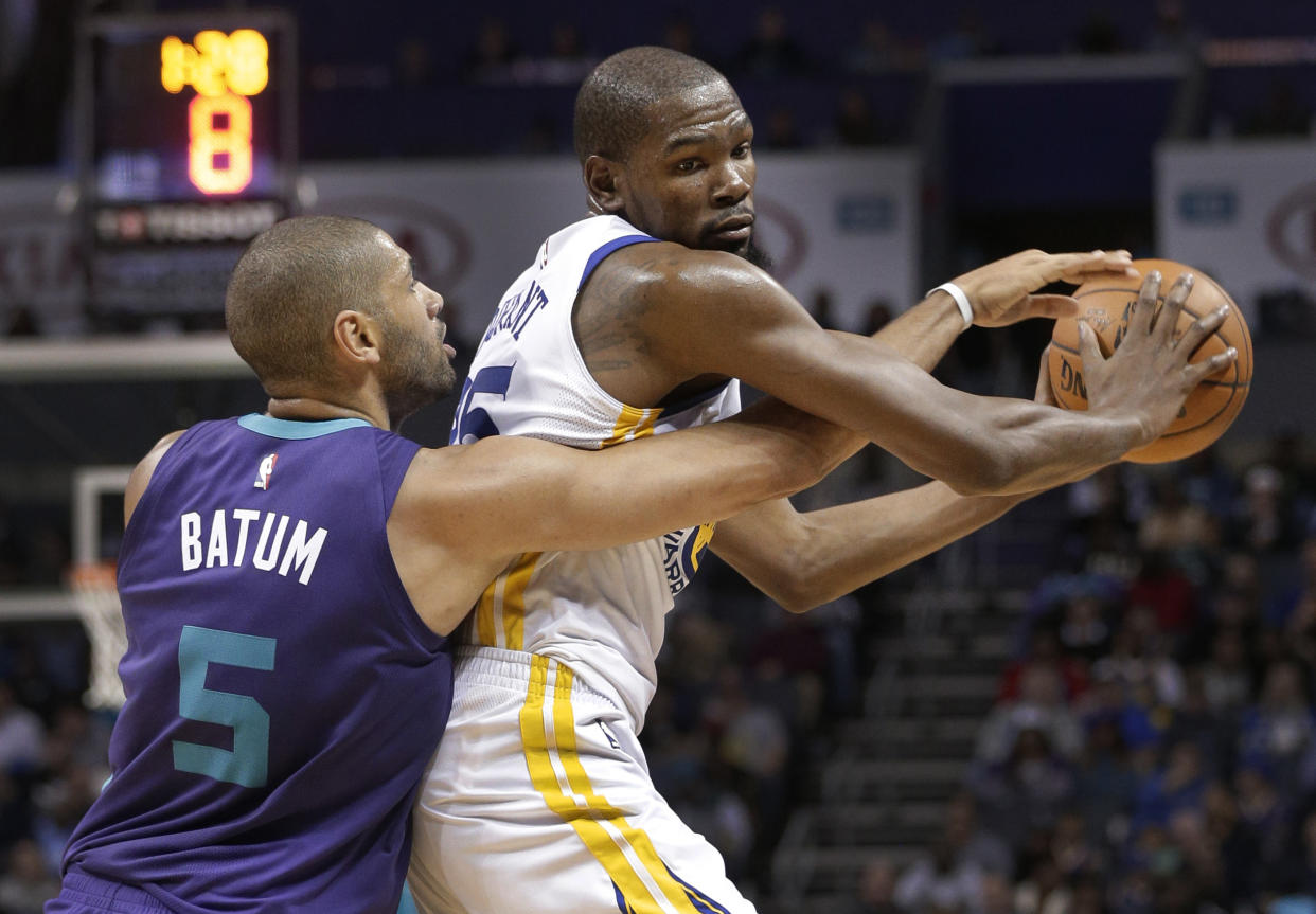 Charlotte Hornets’ Nicolas Batum (5) reaches in on Golden State Warriors’ Kevin Durant (35) during the second half of an NBA basketball game in Charlotte, N.C., Wednesday, Dec. 6, 2017. (AP Photo/Chuck Burton)