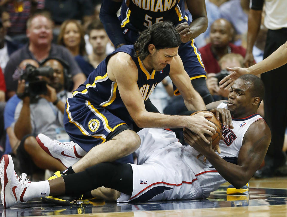 El argentino Luis Scola (izquierda) de los Pacers de Indiana y Paul Millsap de los Hawks de Atlanta se pelean un balón suelto durante el partido de los playoffs de la NBA el jueves 24 de abril de 2014. (AP Foto/John Bazemore)