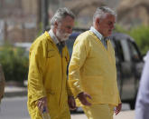 Volker Waldmann, right, and Jim Fitton, left, are handcuffed as they walk to a courtroom in Baghdad, Iraq, Sunday, May 22, 2022. Waldmann and Fitton were accused of smuggling ancient shards out of Iraq. (AP Photo/Hadi Mizban)