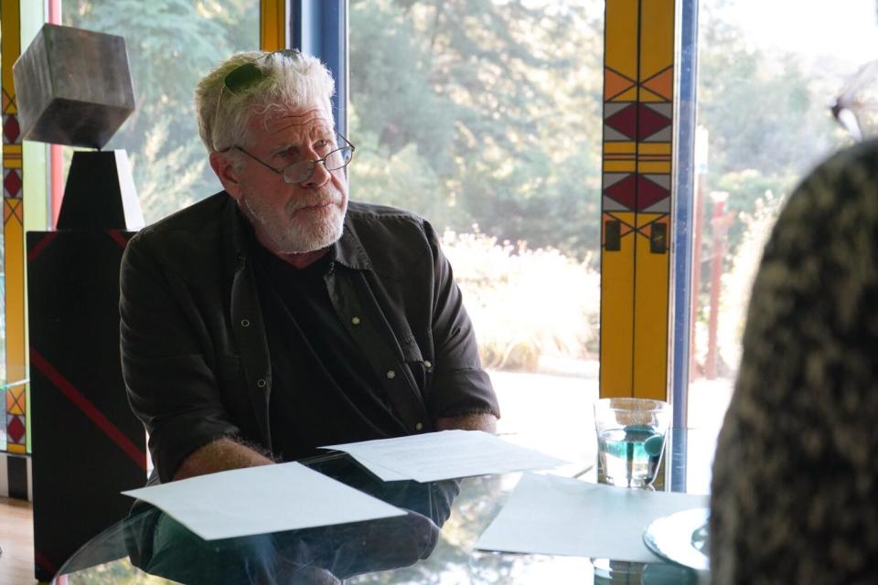 A man sitting at a dining table with papers sitting in front of him.