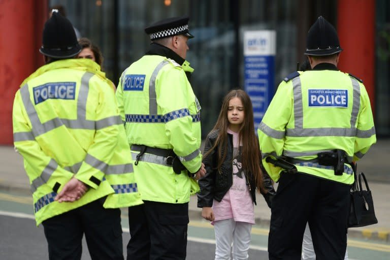 Police talk to people affected by the deadly terror attack at Manchester Arena in Manchester on May 23, 2017