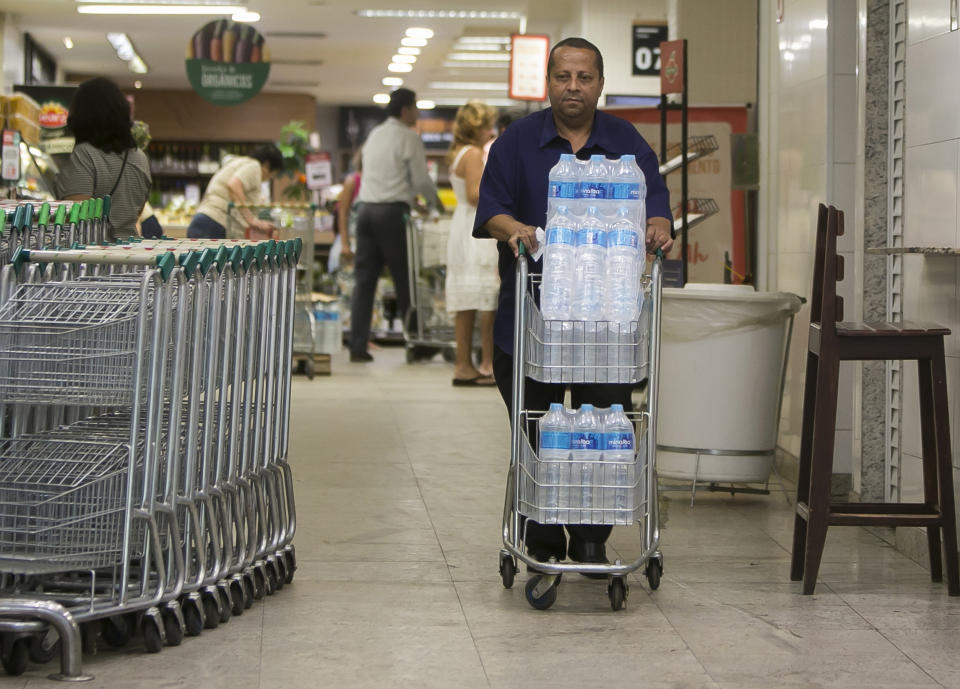 Almir Vicente pushes his recently bought bottled water at a supermarket in the Copacabana neighborhood of Rio de Janeiro, Brazil, Wednesday, Jan. 15, 2020. There’s a creeping sense of alarm in Rio de Janeiro after more than a week of foul tasting and smelling tap water in dozens of neighborhoods, and residents are hoarding bottled water. (AP Photo/Bruna Prado)