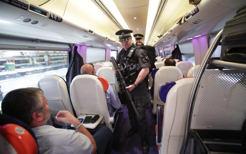 Armed British Transport Police Specialist Operations officers on board a Virgin train to Birmingham New Street at Euston station in London as armed police officers are patrolling on board trains nationwide for the first time - Credit: PA