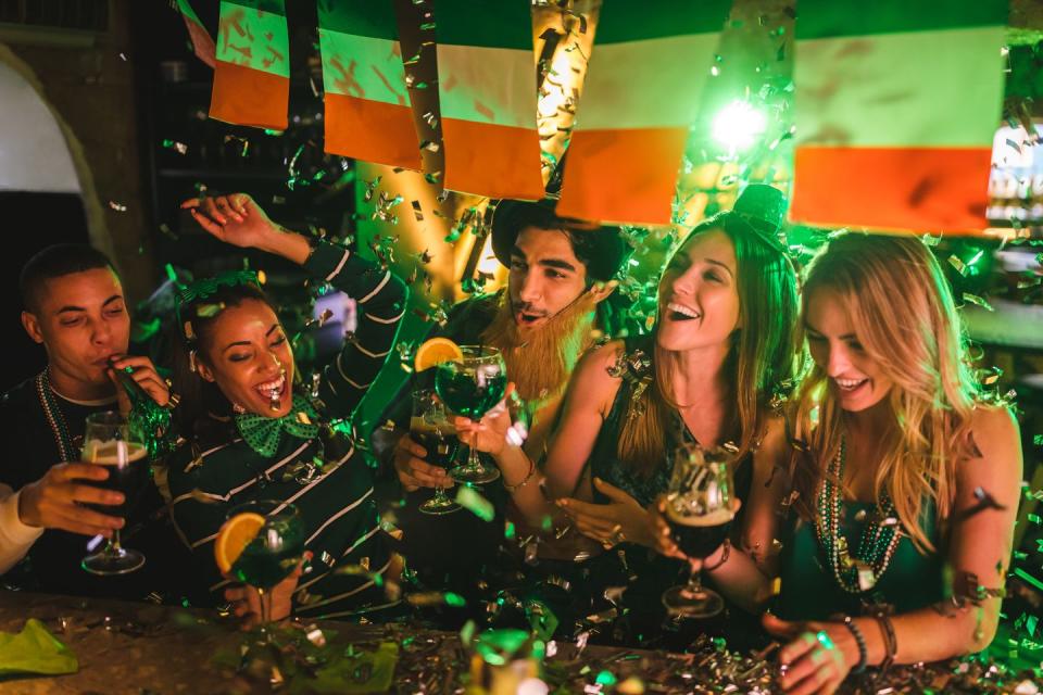 group of friends partying and celebrating at a bar for saint patrick's day