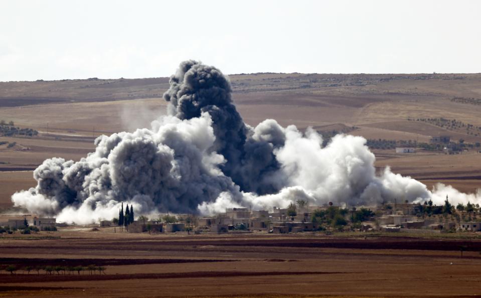 Smoke rises from a village on the outskirts of the Syrian town of Kobani, seen from near the Mursitpinar border crossing on the Turkish-Syrian border in the southeastern town of Suruc in Sanliurfa province October 15, 2014. American-led forces conducted 21 airstrikes near Kobani, Syria, in the last two days to slow the advance of Islamic State militants, the U.S. military said on Tuesday, warning the situation on the ground is fluid as militants try to gain territory. REUTERS/Kai Pfaffenbach (TURKEY - Tags: MILITARY CONFLICT POLITICS TPX IMAGES OF THE DAY)