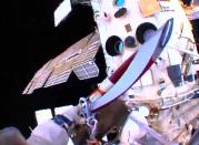 This screen image taken from NASA shows the Sochi Olympic torch being held during a spacewalk on Saturday, Nov. 9, 2013. Video streamed by the US space agency NASA showed Oleg Kotov and Sergei Ryazanskiy carrying the unlit Olympic torch, bobbing weightlessly at the end of a tether in a darkness dotted by stars. The two gingerly maneuvered to take photos of the torch against the background of the planet, the orb’s edge glowing with sunrise. (AP Photo/NASA)