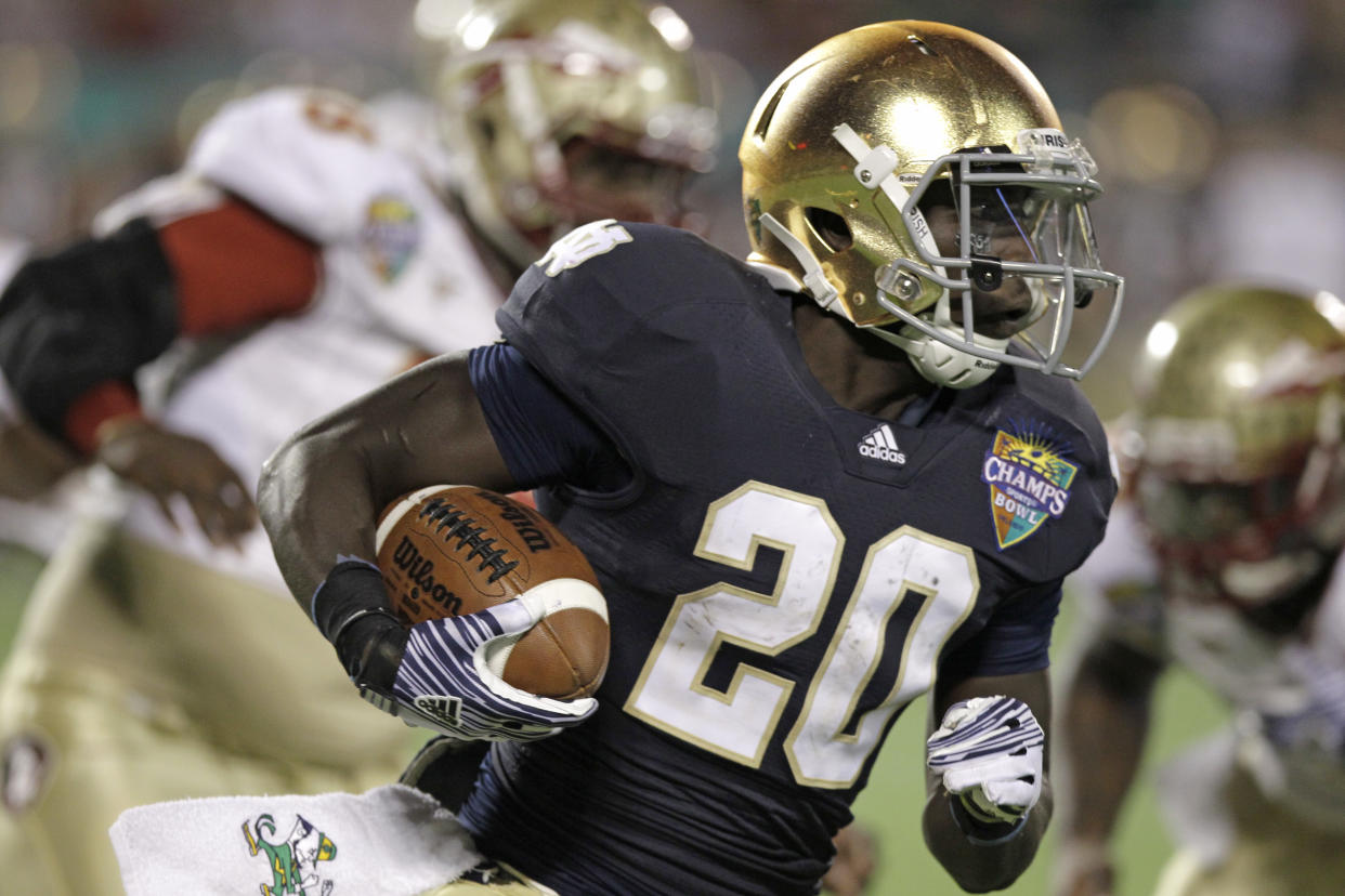 FILE - In this Dec. 29, 2011, file photo, Notre Dame's Cierre Wood gains yardage against Florida State during the second half of the Champs Sports Bowl NCAA college football game in Orlando, Fla. Notre Dame running backs Theo Riddick and Wood would like to get the ball a little more often. Coach Brian Kelly thinks he needs to get the ball to George Atkinson III more often. The three backs, though, say they are all friends and cheer one another. (AP Photo/John Raoux, File)