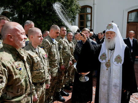 Metropolitan Filaret, the head of the Ukrainian Orthodox Church of the Kiev Patriarchate, sprinkles holy water during a ceremony to bless Easter cakes and eggs which will be transferred to Ukrainian servicemen fighting in east Ukraine, in central Kiev, Ukraine April 12, 2017. Picture taken April 12, 2017. REUTERS/Gleb Garanich