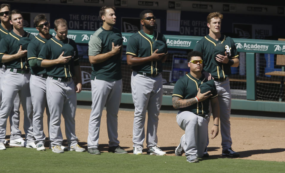 Oakland Athletics catcher Bruce Maxwell takes a knee next to teammate Mark Canha (R) during the national anthem before a baseball game against the Texas Rangers in Arlington, Texas, Sunday, Oct. 1, 2017. (AP Photo/LM Otero)