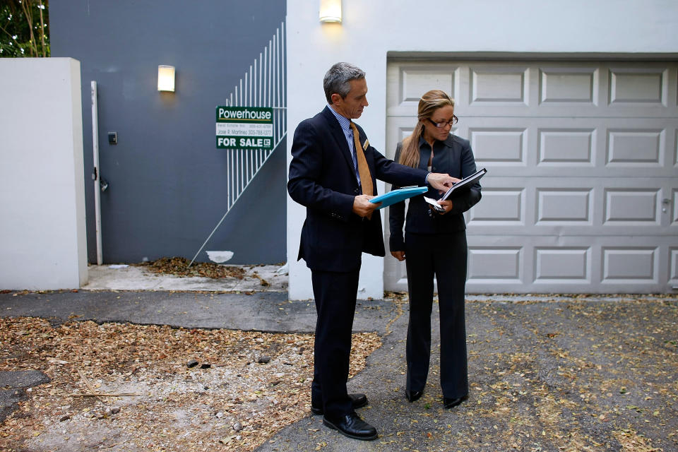 Real estate agents, Izzy Buholzer from Home and Business Realty, Inc. and Shellie Young from Fortune International Realty look at a house, for their prospective clients, that originally was on the market for over one million dollars and is now selling in the six hundred thousand dollar range in Miami, Florida. (Credit: Joe Raedle, Getty Images)