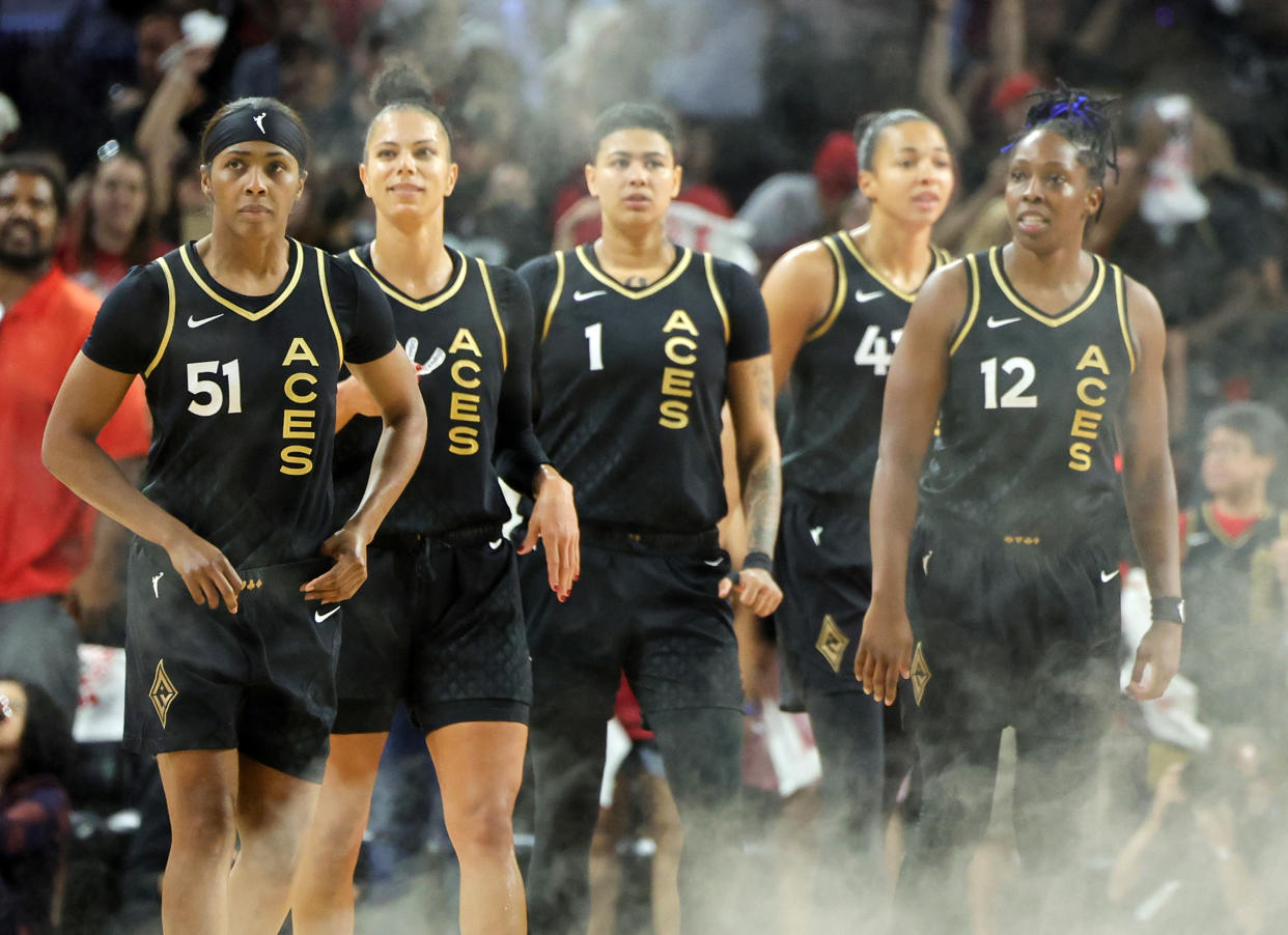 Sydney Colson leads Las Vegas Aces teammates Alysha Clark, Kierstan Bell, Kiah Stokes and Chelsea Gray on the court after a smoke effect emanated from the scoreboard during the 2023 WNBA playoffs at Las Vegas' Michelob Ultra Arena. (Photo by Ethan Miller/Getty Images)