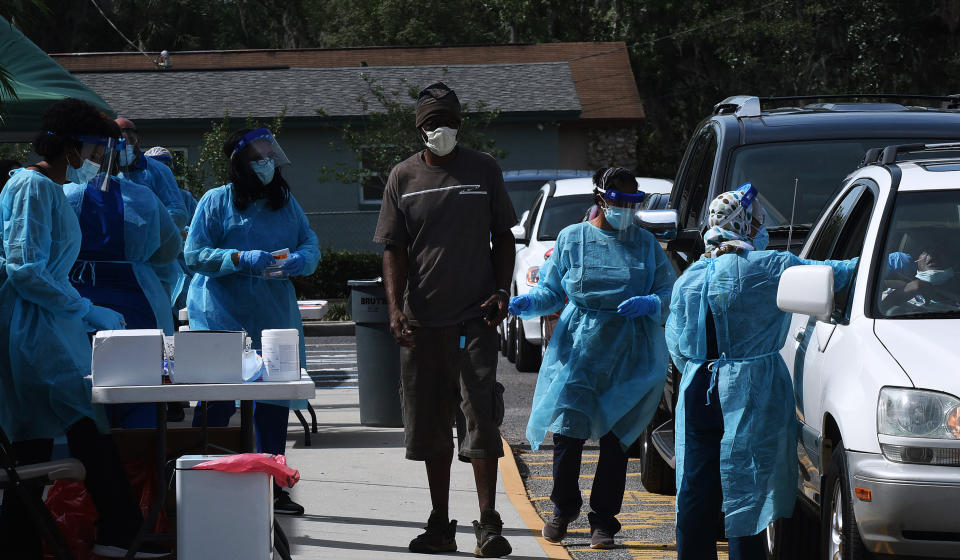 Health workers are seen at a mobile COVID-19 testing site in the Goldsboro neighborhood of Sanford, Florida on April 23, 2020. Local health officials are offering the free tests at six historic Black communities in Seminole County to help residents who are not only especially vulnerable to coronavirus, but who cannot drive to a health clinic or may be unable to afford health insurance.  (Photo by Paul Hennessy/NurPhoto via Getty Images)