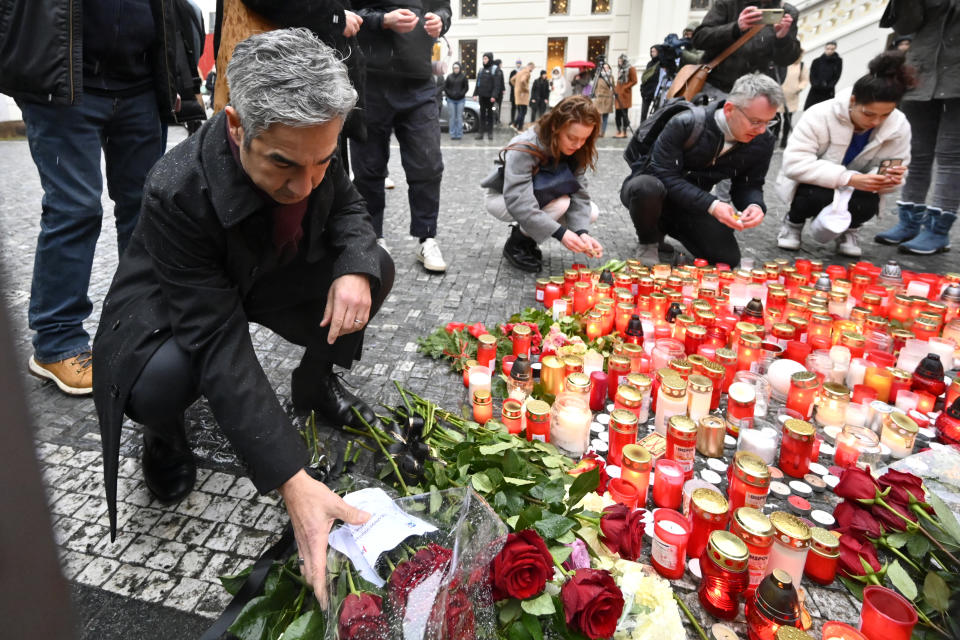 US Ambassador to the Czech Republic Bijan Sabet lays flowers outside the headquarters of Charles University for victims of mass shooting in Prague, Czech Republic, Friday, Dec. 22, 2023. A lone gunman opened fire at a university on Thursday, killing more than a dozen people and injuring scores of people. (AP Photo/Denes Erdos)