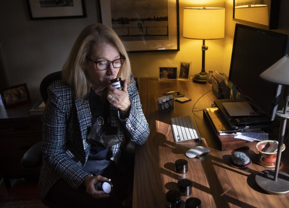 Susan Robbins Newirth sniffs essential oils at her desk