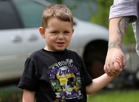 Joshua Sekerak holds the hand of his mom Jennifer at their home in Leetonia, Ohio, United States on May 21, 2016. REUTERS/Aaron Josefczyk