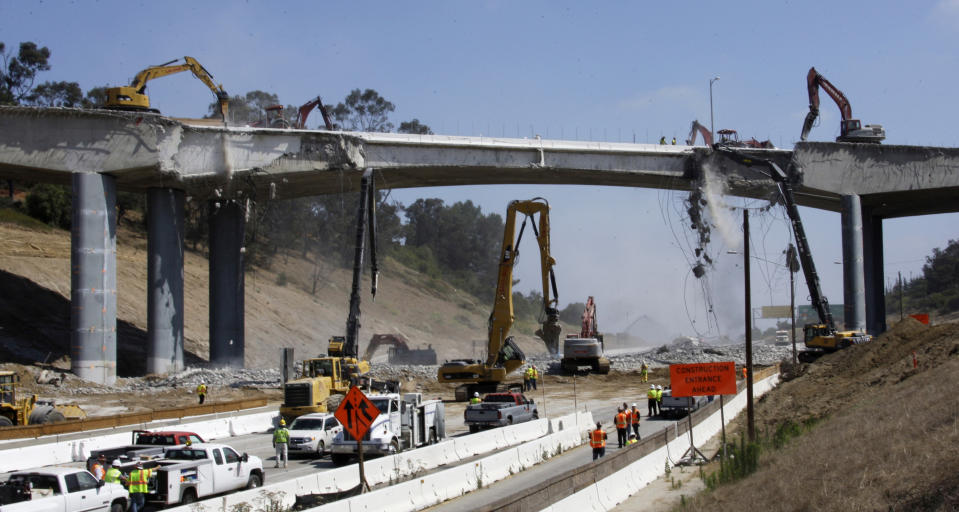 FILE - In this July 16, 2011 file photo, pneumatic hammers from above and below continue the demolition of two lanes of Mulholland Drive bridge over Interstate 405 in Los Angeles as part of what was called Carmageddon, as it required the closure of the freeway for three days. "Carmageddon II" will be coming to a major freeway near Los Angeles on the last weekend of April. The demolition of the Burbank Boulevard bridge over Interstate 5 in Burbank, Calif., a major link between Los Angeles and Northern California, will shut down the freeway for what authorities say will be 36 hours beginning at 3 p.m., Saturday, April 25, 2020. (AP Photo/Reed Saxon, File)
