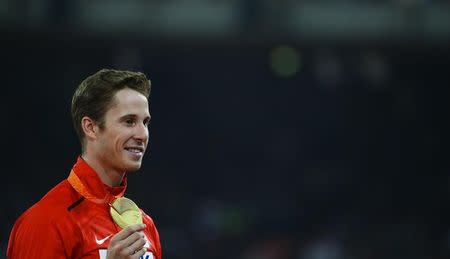 First placed Derek Drouin of Canada poses during the medals ceremony after the men's high jump final at the 15th IAAF World Championships at the National Stadium in Beijing, China, August 30, 2015. REUTERS/Damir Sagolj