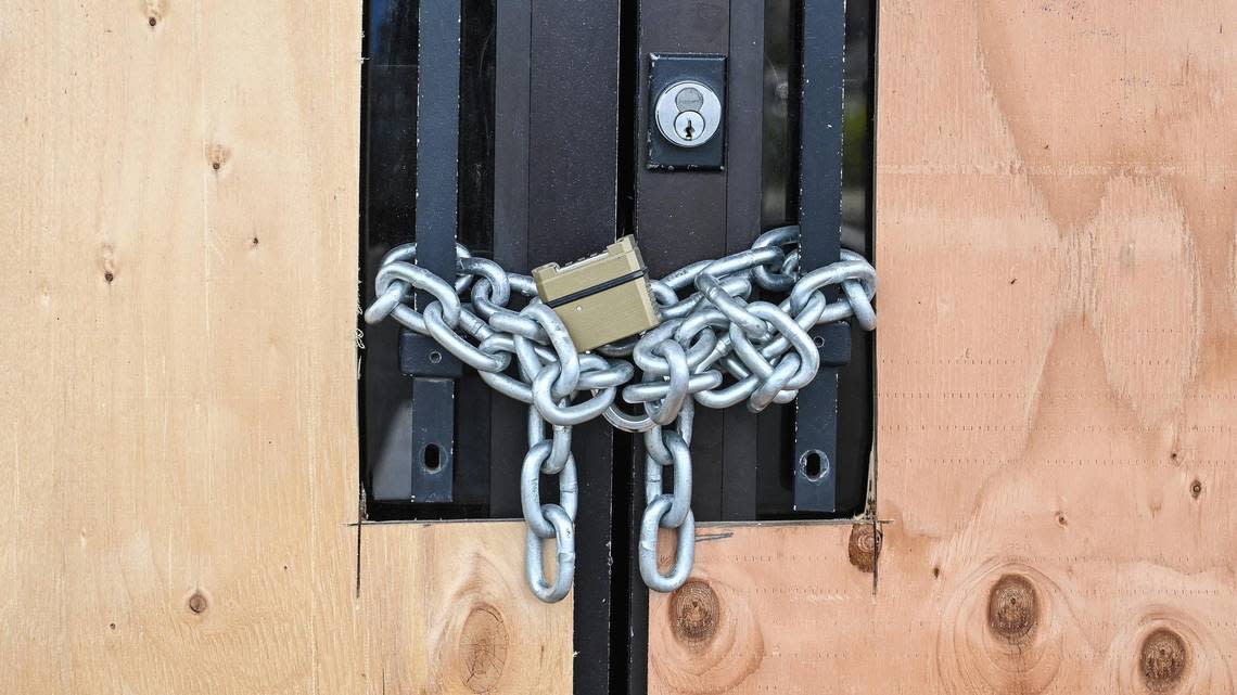 A chain and lock secure the door at the Burger King in front of Fashion Fair mall which is now closed and boarded up with all signs removed on Thursday, Feb. 2, 2023.