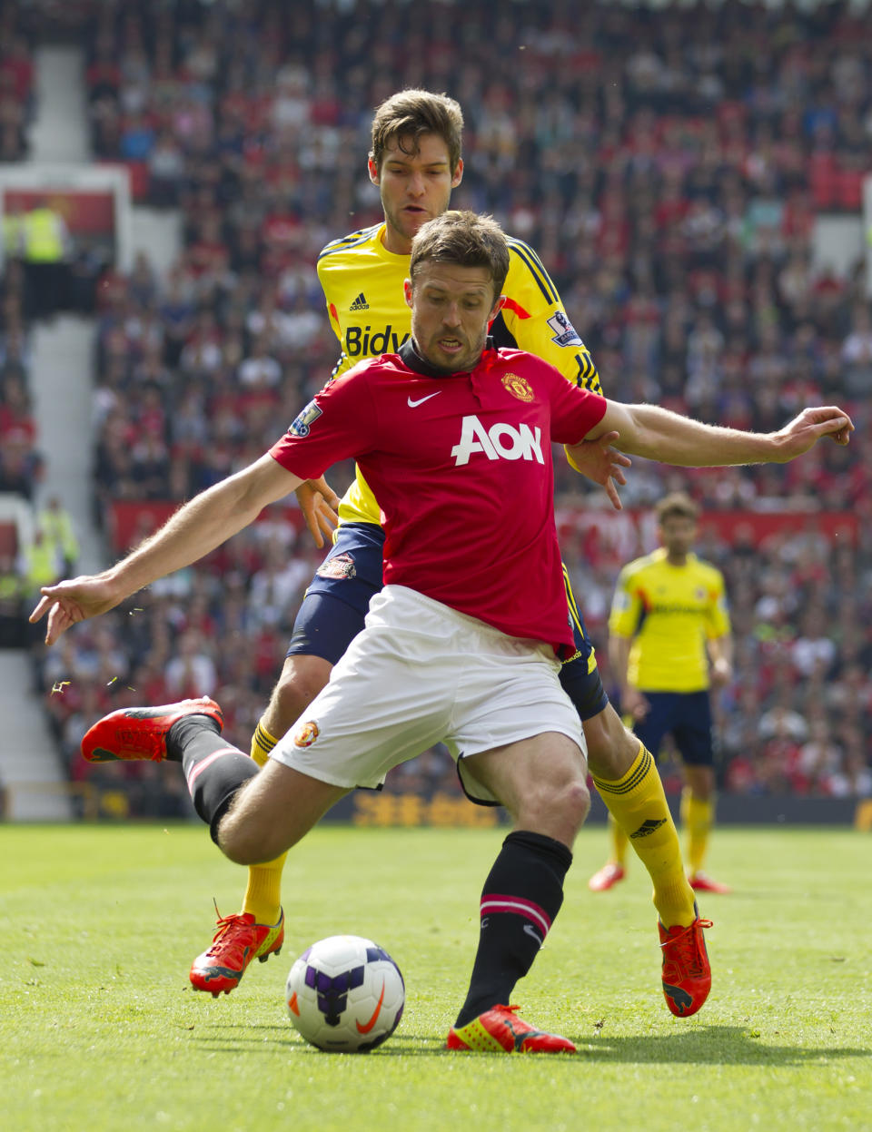 Manchester United's Michael Carrick, foreground, keeps the ball from Sunderland's Marcos Alonso during their English Premier League soccer match at Old Trafford Stadium, Manchester, England, Saturday May 3, 2014. (AP Photo/Jon Super)