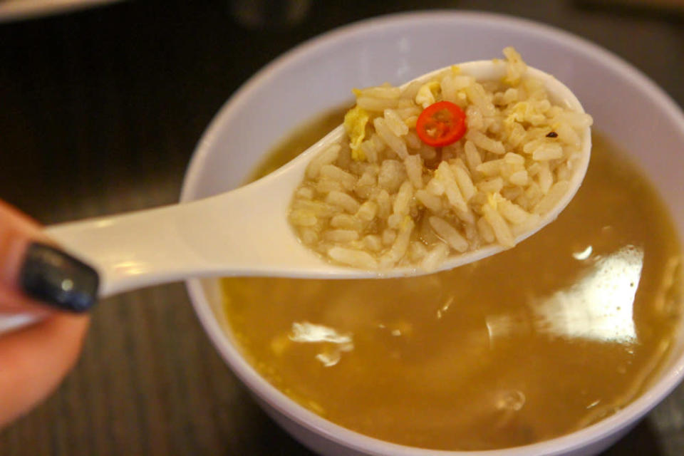 Close up of a spoonful of rice and soup