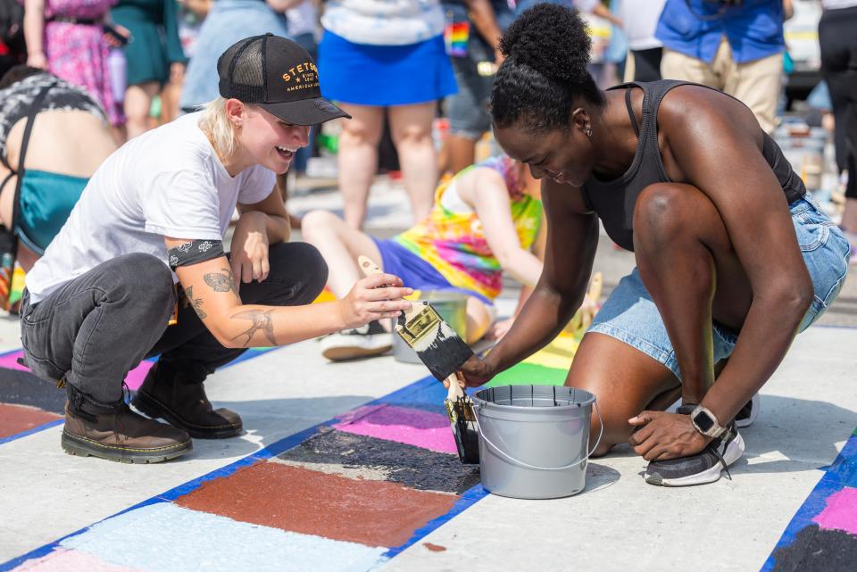 Kaylin Underwood, left and Kaleah Bridgeforth, right, participate in a painting party held to create Nashville’s first rainbow crosswalk in the intersection of 14th St. and Woodland St. Saturday, June 29, 2024.