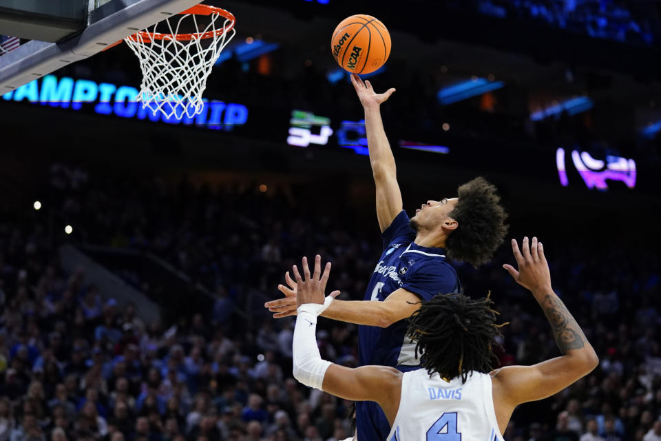 St. Peter's Daryl Banks III, top, goes up for a shot against North Carolina's R.J. Davis during the first half of a college basketball game in the Elite 8 round of the NCAA tournament, Sunday, March 27, 2022, in Philadelphia. (AP Photo/Matt Rourke)