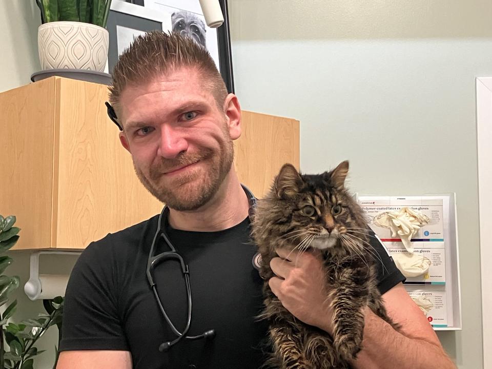 Dr. Andrew Scherrer, formerly of Phillips Animal Hospital, holds Katy the cat on his last day on the job. He saved her life during surgery six years ago. Mark Caudill