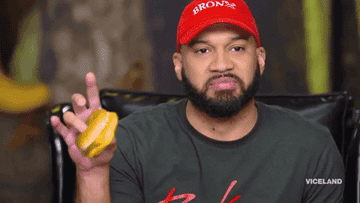 A man biting a sandwich and making a disgusted face