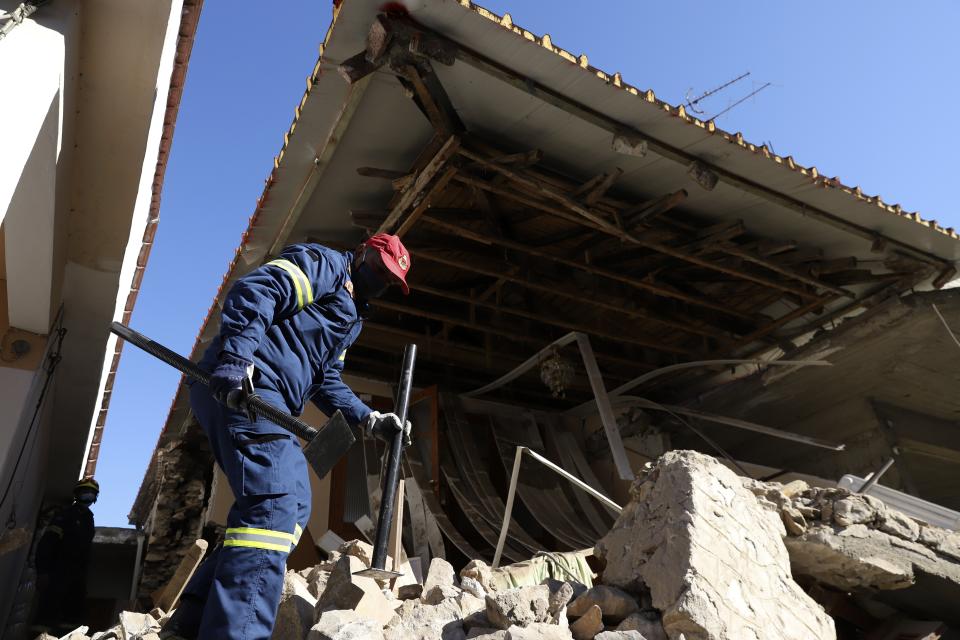 A firefighter checks a damaged house after an earthquake in Damasi village, central Greece, Thursday, March 4, 2021. Fearful of returning to their homes, many thousands of people in central Greece spent the night outdoors after a powerful earthquake Wednesday, felt across the region leaving many damaged homes and public buildings.(AP Photo/Vaggelis Kousioras)
