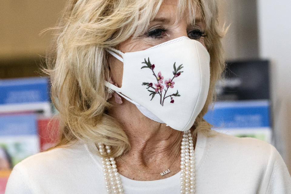 First lady Jill Biden's necklace says "Mama," as she takes a tour of Whitman-Walker Health, Friday, Jan. 22, 2021, in Washington. (AP Photo/Jacquelyn Martin, Pool)