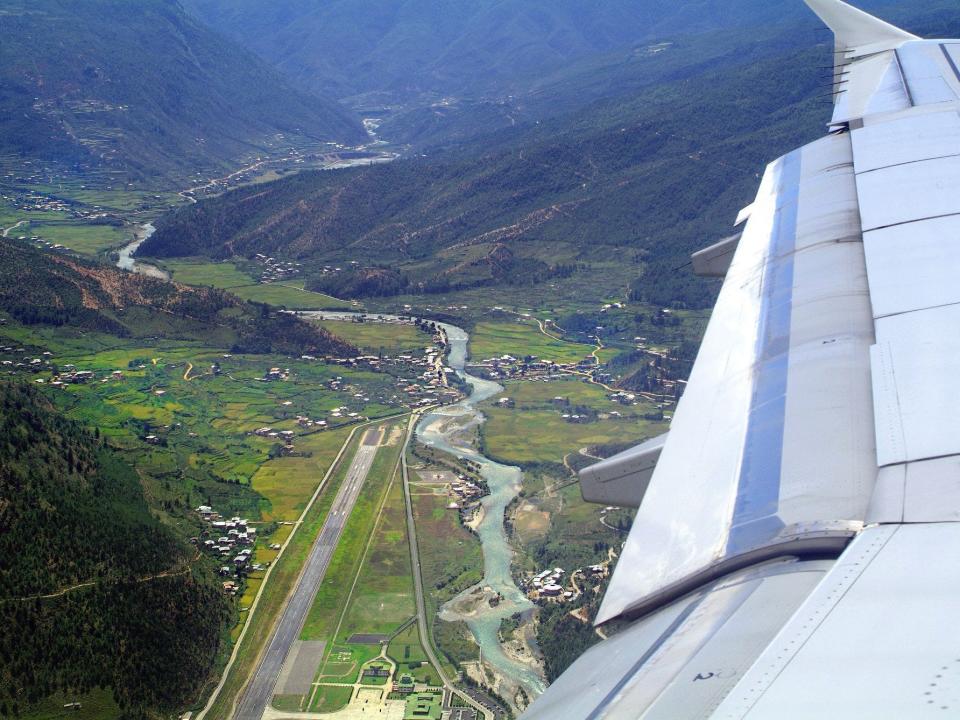 A plane landing at Paro airport looking down at the runway from above.