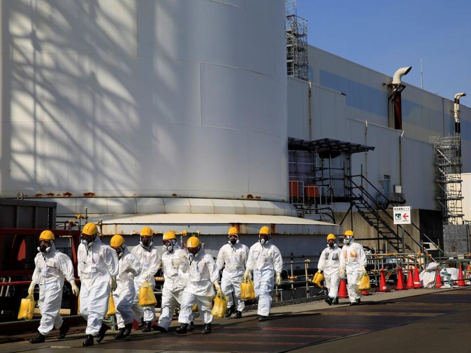 Workers walk near No. 2 and No. 3 reactor buildings at the tsunami-crippled Fukushima Daiichi nuclear power plant in Okuma town