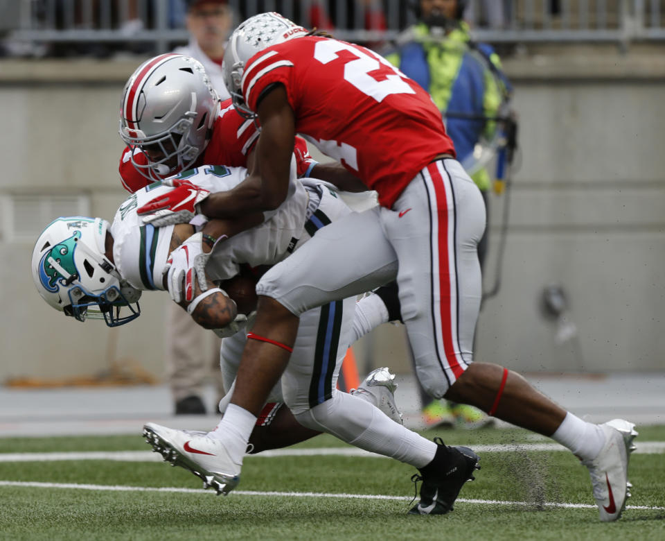 Tulane receiver Terren Encalade, left, makes a catch between Ohio State defenders Jeffrey Okudah, center, Shaun Wade during the first half of an NCAA college football game Saturday, Sept. 22, 2018, in Columbus, Ohio. (AP Photo/Jay LaPrete)