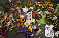 <p>Flowers, candles and chalk-written messages surround a photograph of Heather Heyer on the spot where she was killed and 19 others injured when a car slamed into a crowd of people protesting against a white supremacist rally, Aug. 16, 2017 in Charlottesville, Va. (Photo: Chip Somodevilla/Getty Images) </p>