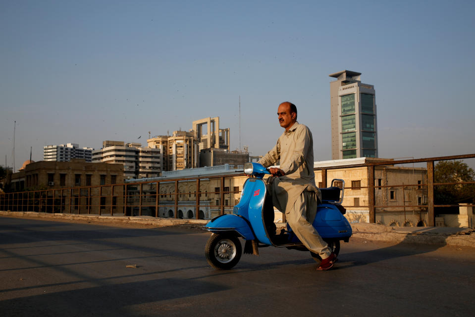 <p>Journalist Arif Balouch, 48, poses for a photograph with his 1980 model Vespa scooter in Karachi, Pakistan, March 2, 2018. “For me, a Vespa scooter is like a family tradition. My father used to ride this and I myself find this very good as it has two separate comfortable seats which is uncommon, it has a compartment to keep things which is also uncommon and for safety it guards your knees during accidents. I would say it’s the BMW of scooters,” Balouch said. (Photo: Akhtar Soomro/Reuters) </p>