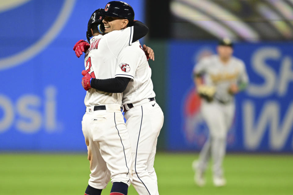 Cleveland Guardians second baseman Andres Gimenez, right, is hugged by Tyler Freeman after driving in the winning run with a single during the 10th inning of a baseball game against the Oakland Athletics, Tuesday, June 20, 2023, in Cleveland. (AP Photo/David Dermer)