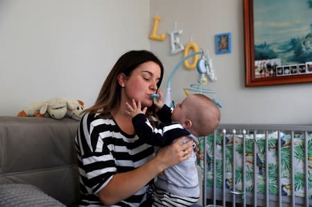 Karolina Burczyk is pictured with her son Leon in her home in Nowa Karczma