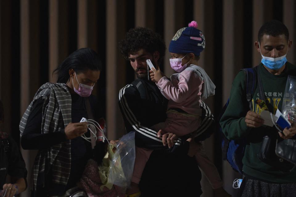 Families of migrants wait to be processed by US Border Patrol after illegally crossing the US-Mexico border in Yuma, Arizona in the early morning of July 11, 2022.  / Credit: ALLISON DINNER/AFP via Getty Images