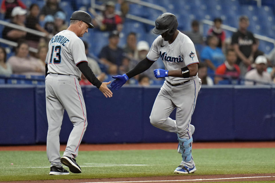 Miami Marlins' Jorge Soler, right, shakes hands with third base coach Al Pedrique after his solo home run off Tampa Bay Rays starting pitcher Drew Rasmussen during the fourth inning of a baseball game Wednesday, May 25, 2022, in St. Petersburg, Fla. (AP Photo/Chris O'Meara)