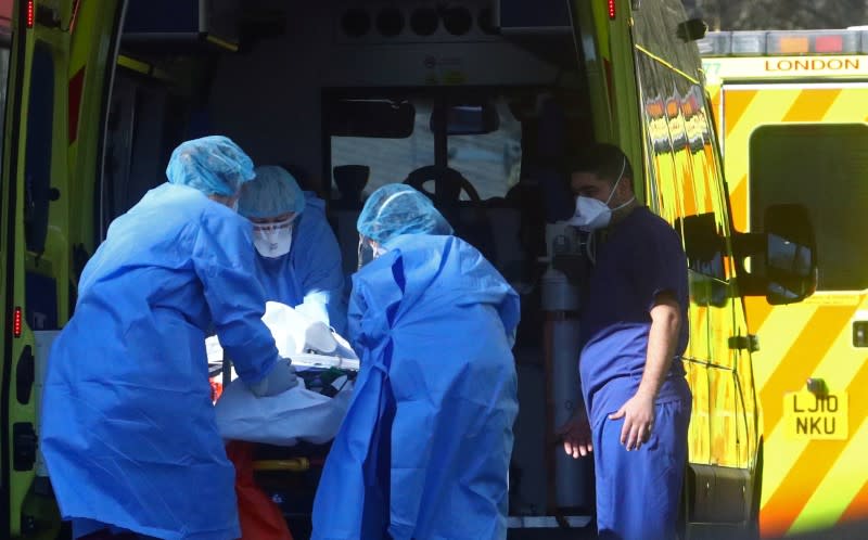 Medical staff with a patient at the back of an ambulance outside St Thomas's hospital as the spread of the coronavirus disease (COVID-19) continues in London