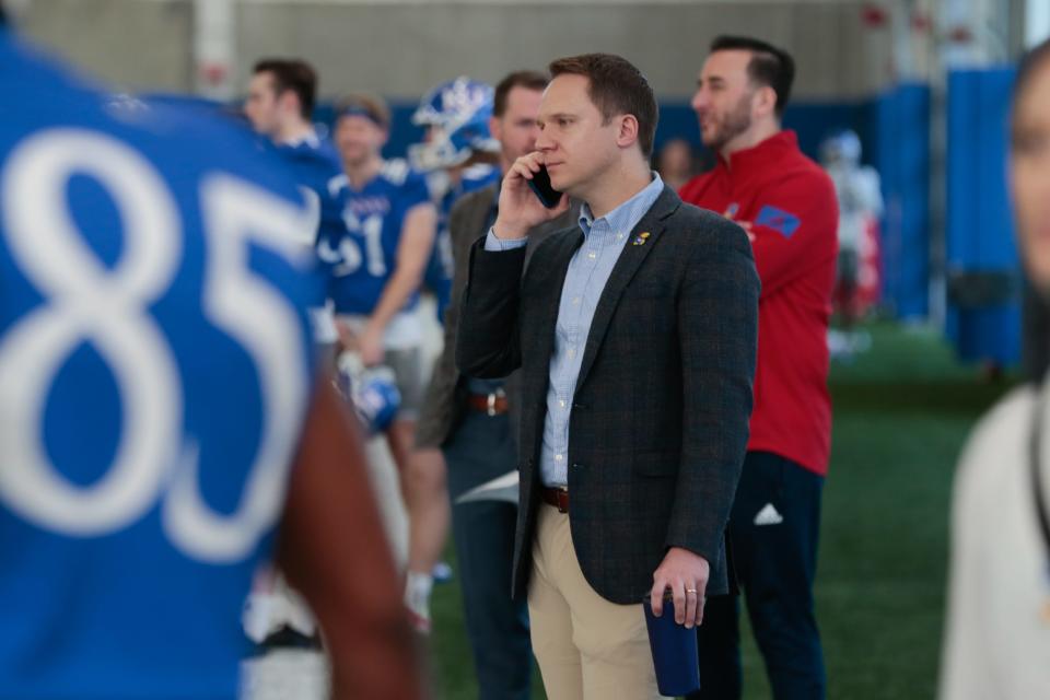 Kansas athletic director Travis Goff speaks on the phone during a football practice this year in Lawrence.