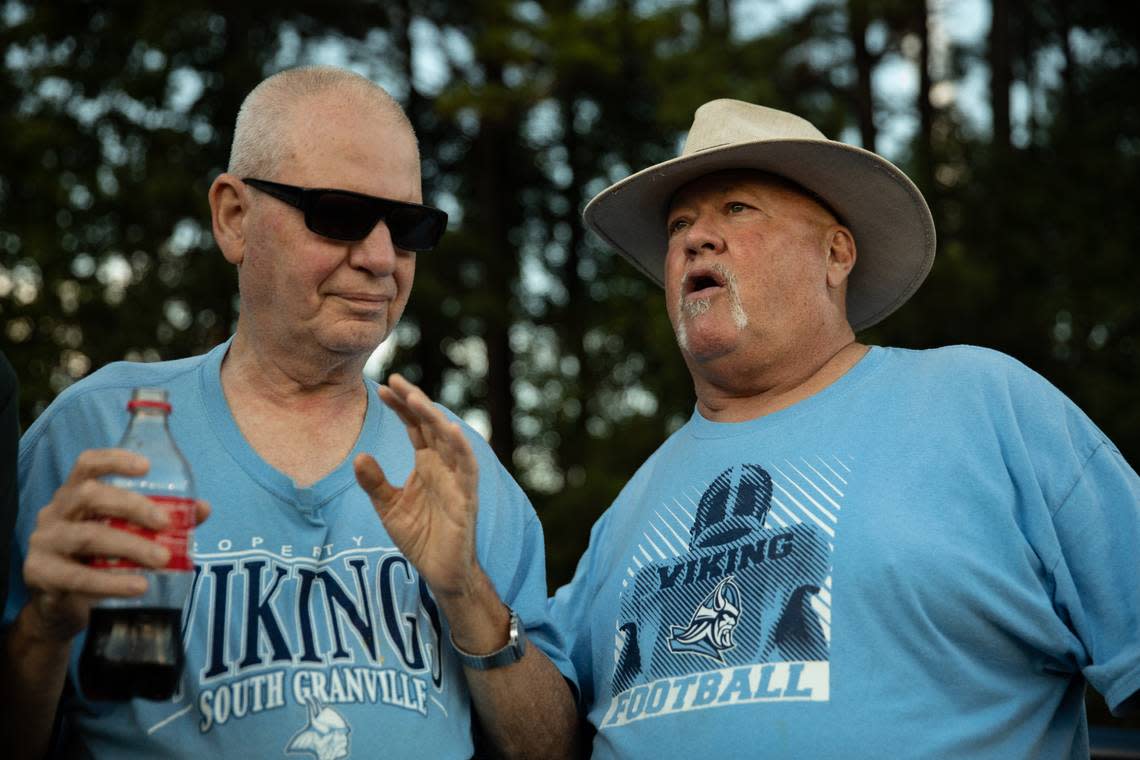 Tom Husketh, left, listens as Hayden Shackelford delivers a play-by-play of a South Granville High School home game. Husketh is blind, and Shackelford narrates the play-by-play to him. The two have been to most of Husketh’s alma mater’s home games.