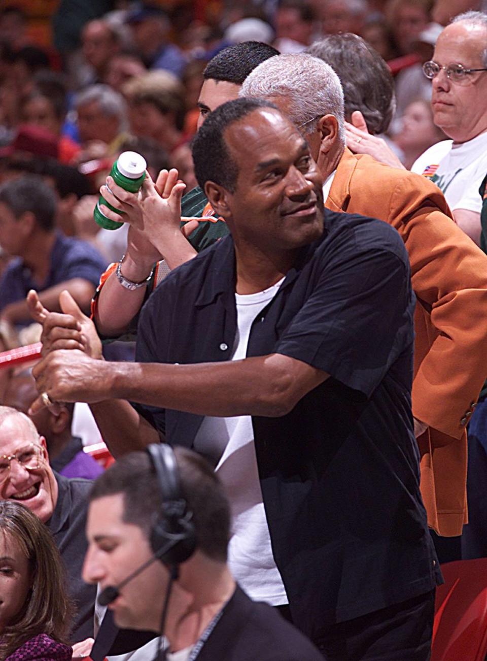 En 2001, O.J. Simpson practica su swing de golf mientras está en las gradas del partido de basquetbol de UM-Indiana en el estadio del downtown de Miami.