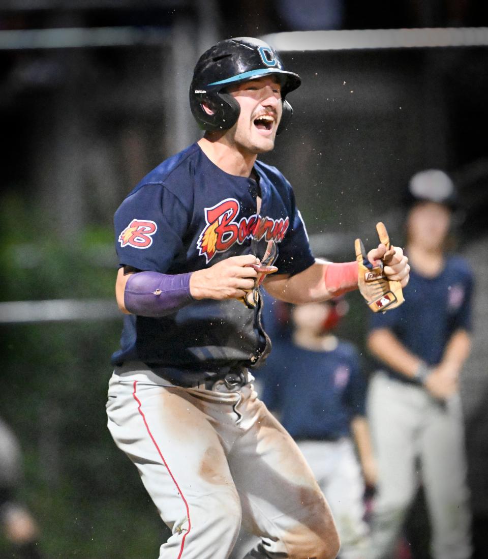 Derek Bender of Bourne celebrates after scoring their fourth run against Orleans on a hit by Sam Peterson.