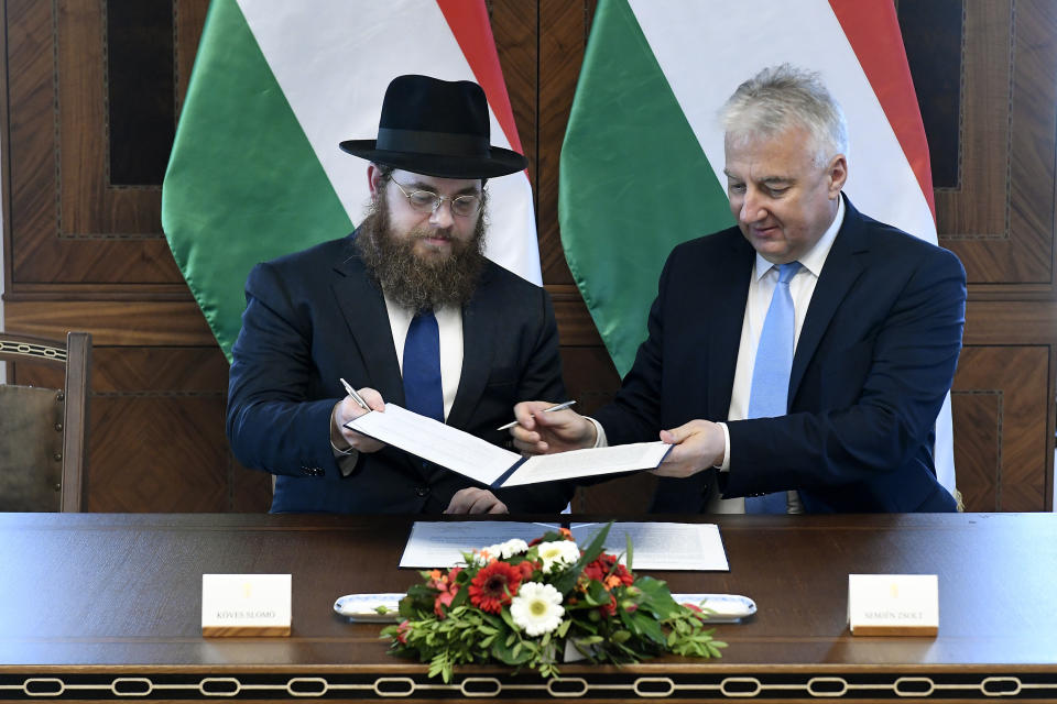 Deputy prime minister in charge of Hungarian communities abroad, church policy and national and ethnic minorities, Zsolt Semjen, right, and Chief Rabbi of the Unified Israelite Congregation of Hungary (EMIH) Slomo Koves sign a comprehensive agreement at the Castle District premises of the Prime Minister's Office, in Budapest, Hungary, Monday, Nov. 18, 2019. By signing the agreement, the Hungarian state acknowledges the historical traditions of the Jewish community and "EMIH's service to the renaissance of Hungary's Jewish community", Semjen said at the signing ceremony.