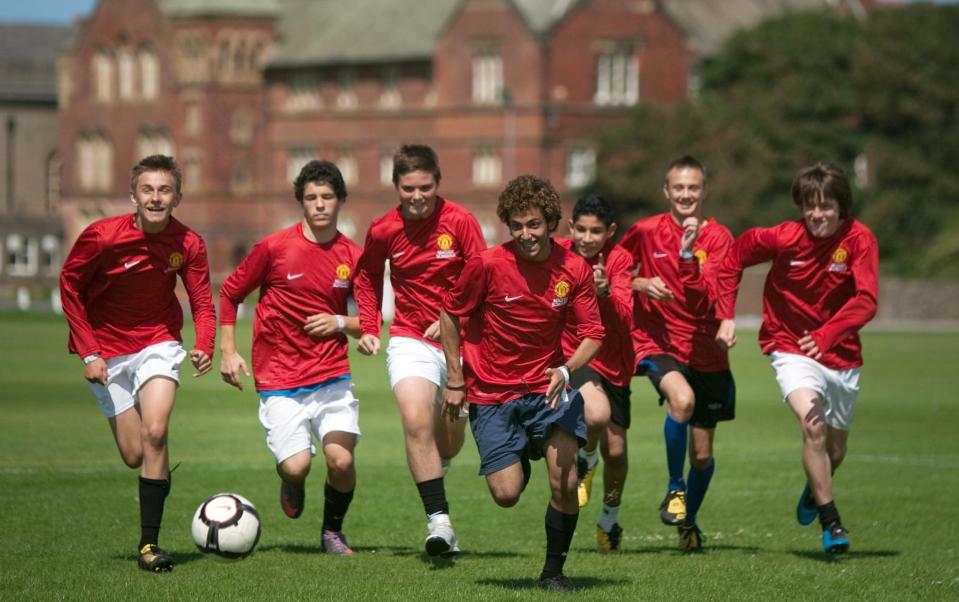 Pupils playing football at Rossall School - ALAMY