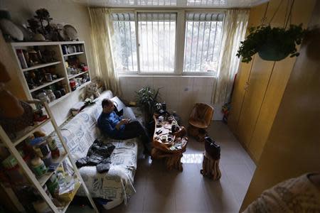 51 year-old Tian Lianpu, father of the late Tian Yao, born in August 1990 and died in January 2012 of lymphoma, looks at his mobile phone as he drinks tea at home in Beijing, December 26, 2013. REUTERS/Jason Lee