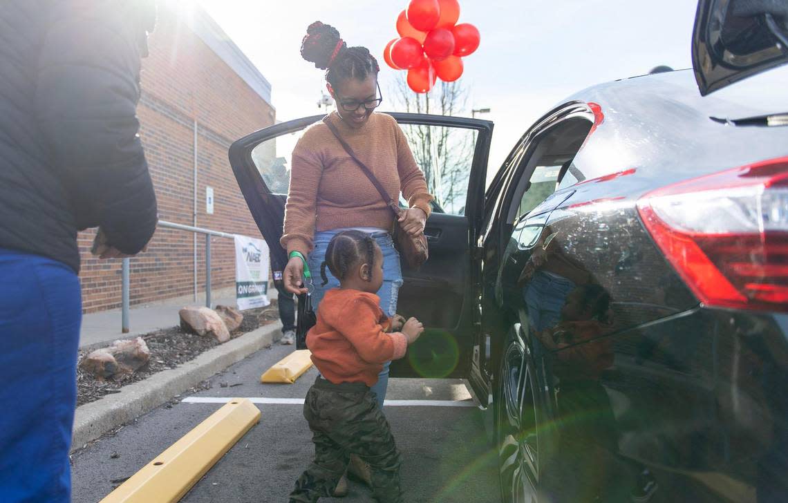 Tyisha Russell helps her 2-year-old son, Jeremiah, get into a car donated to her family from the Urban League of Greater Kansas City on Wednesday, Jan. 11, 2023, in Kansas City.